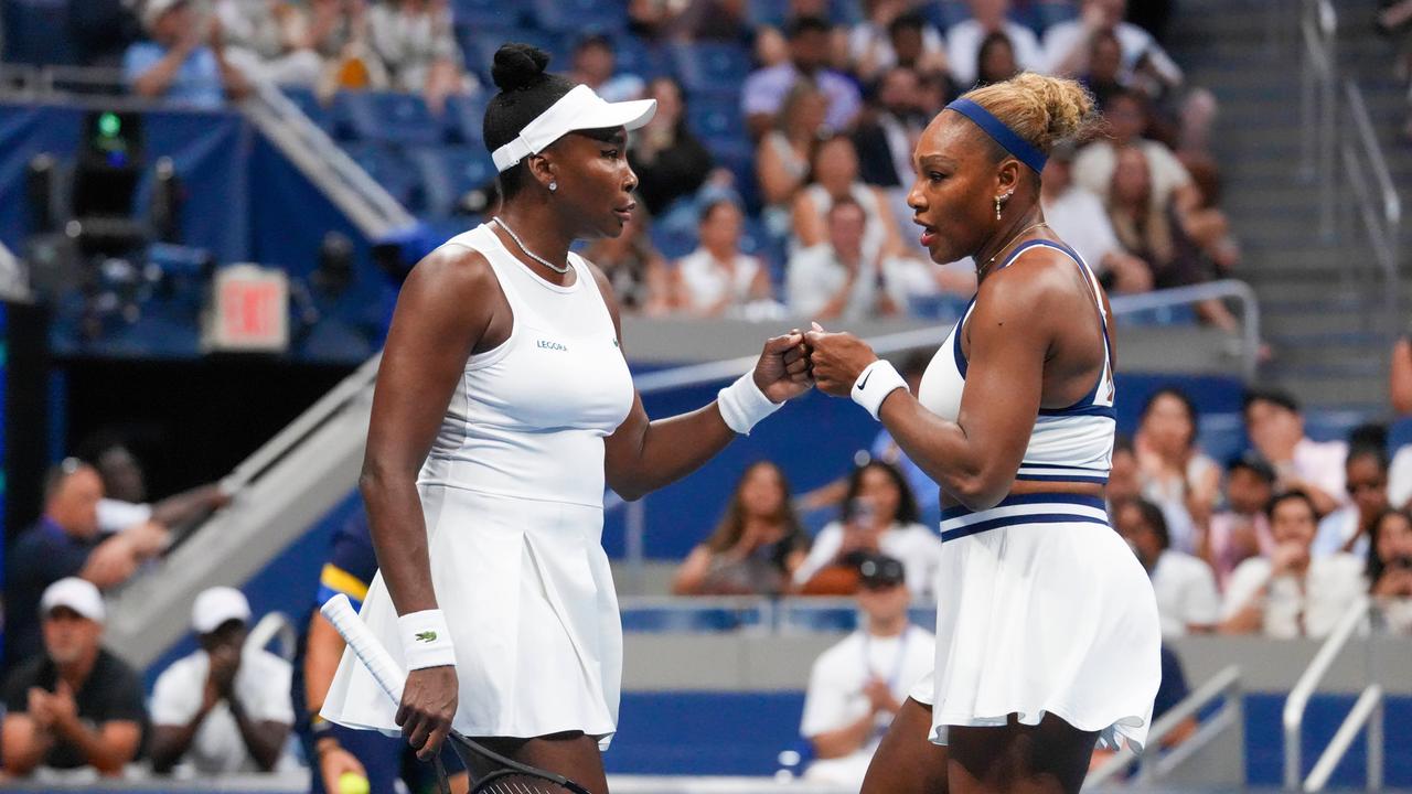 Venus und Serena Wlliams stehen sich gegenüber. Sie sind in einem Tennisstadion. Sie berühren sich mit den Fäusten, geben sich also einen fistbump. 