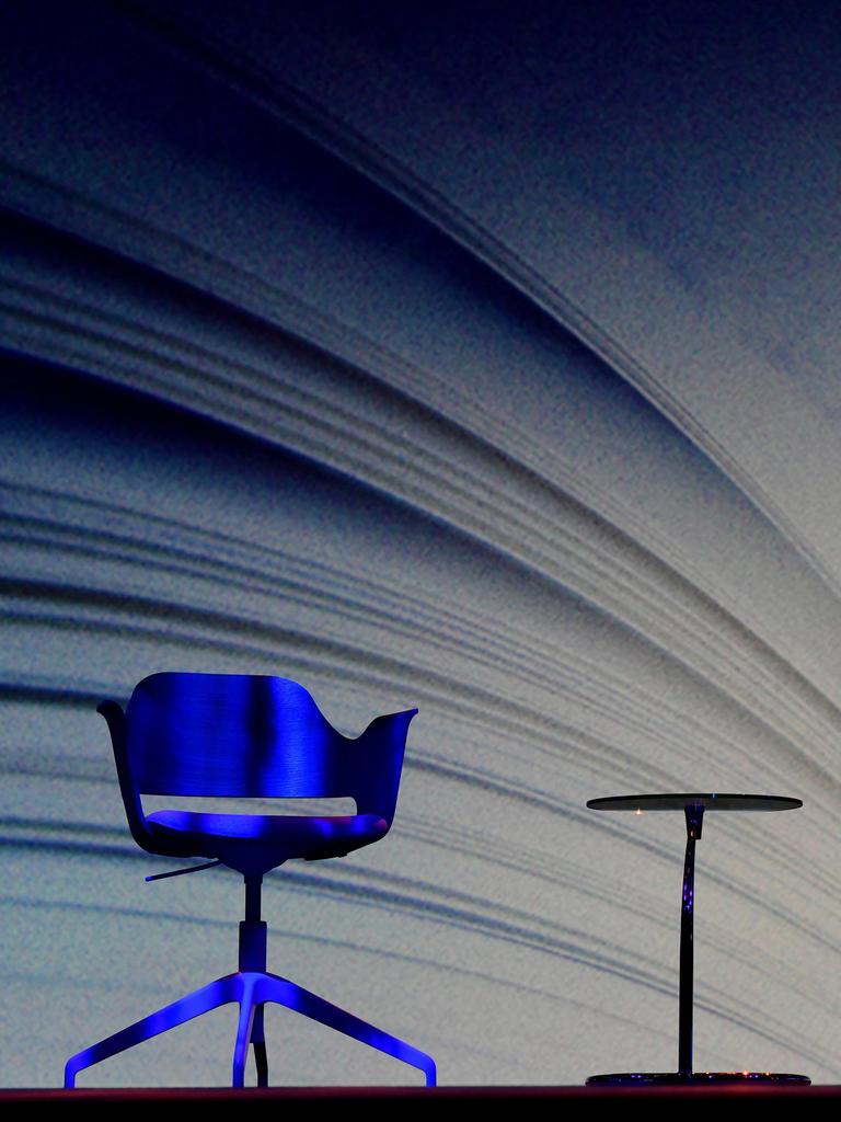 Zwei leere Stühle und ein Tisch stehen vor einer riesigen Buchprojektion auf der Frankfurter Buchmesse.