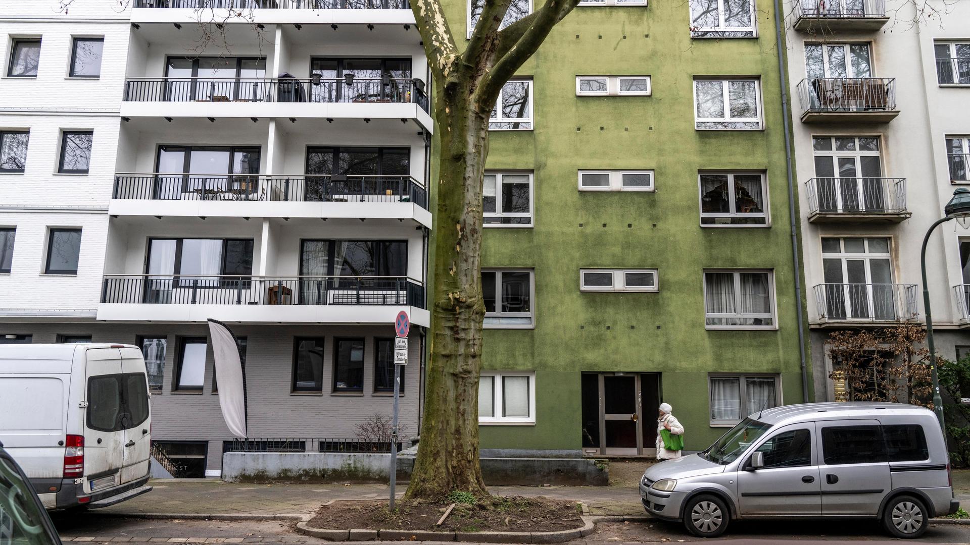 Straße mit Mietwohnungen und Eigentumswohnungen in Düsseldorf-Düsseltal. Weiße und ein grünes Haus wechseln sich in der Reihe ab. 