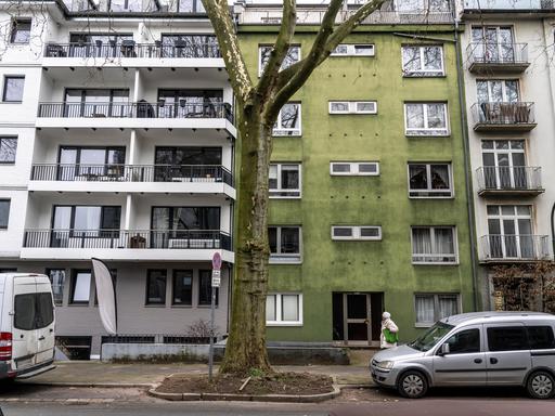 Straße mit Mietwohnungen und Eigentumswohnungen in Düsseldorf-Düsseltal. Weiße und ein grünes Haus wechseln sich in der Reihe ab. 