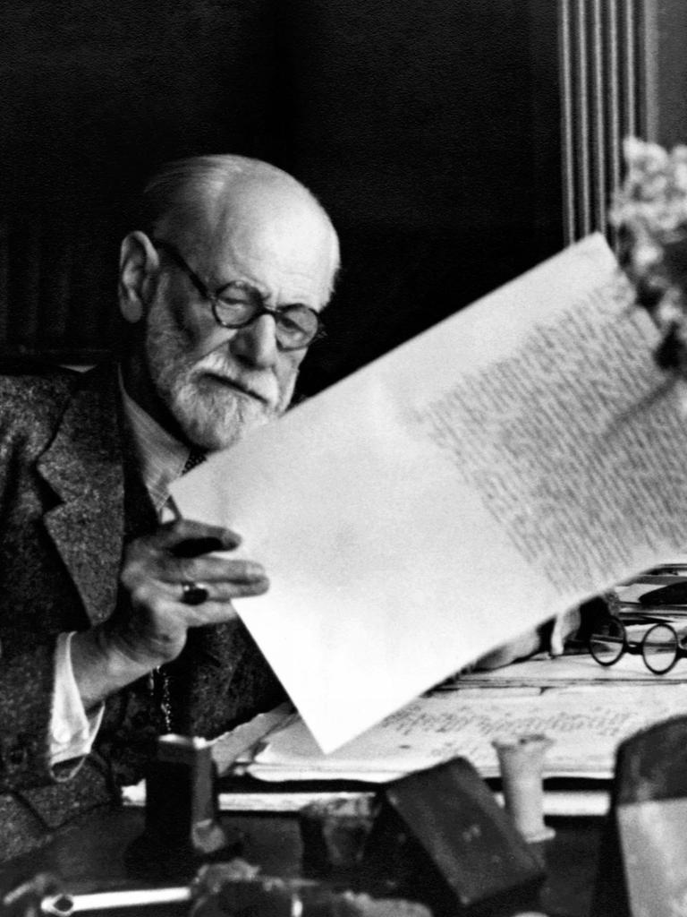 Ein historisches schwarz-weiß-Foto zeigt Sigmund Freud beim Verfassen eines Briefs. Aufnahmedatum unbekannt.