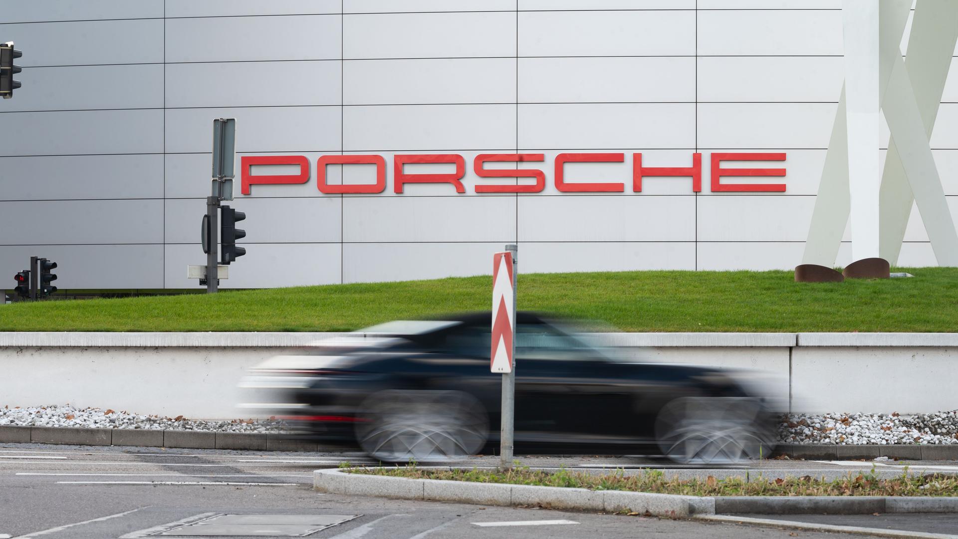 Ein Porsche fährt an der Hauptniederlassung der Porsche AG vorbei.