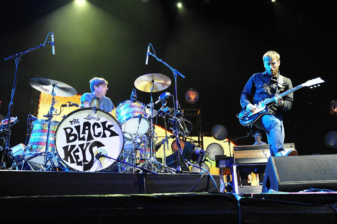 Der Schlagzeuger Patrick Carney und der Gitarrist und Sänger Dan Auerbach stehen spielend auf einer grell beleuchteten Bühne und agieren miteinander neben der Trommel mit dem Schriftzug "Black Keys".