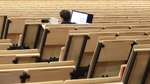 An der Universität Leipzig sitzt ein Informatikstudent bei einer digitalen Vorlesung allein im Auditorium maximum. 