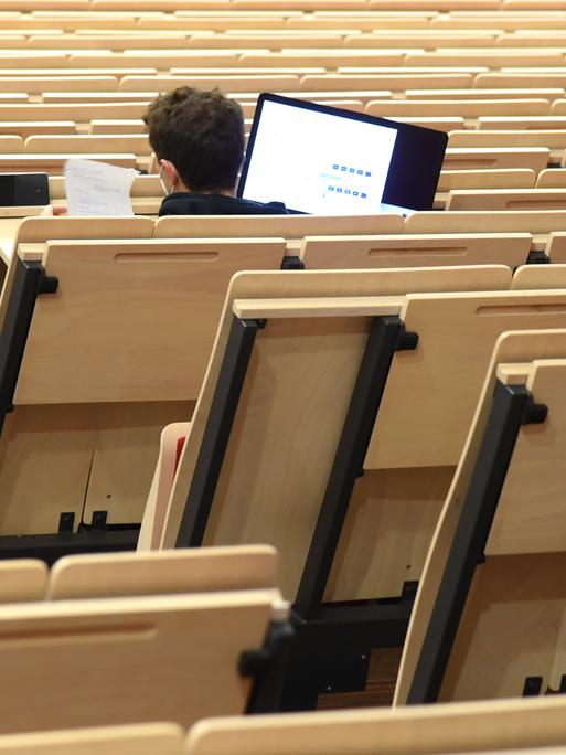 An der Universität Leipzig sitzt ein Informatikstudent bei einer digitalen Vorlesung allein im Auditorium maximum. 