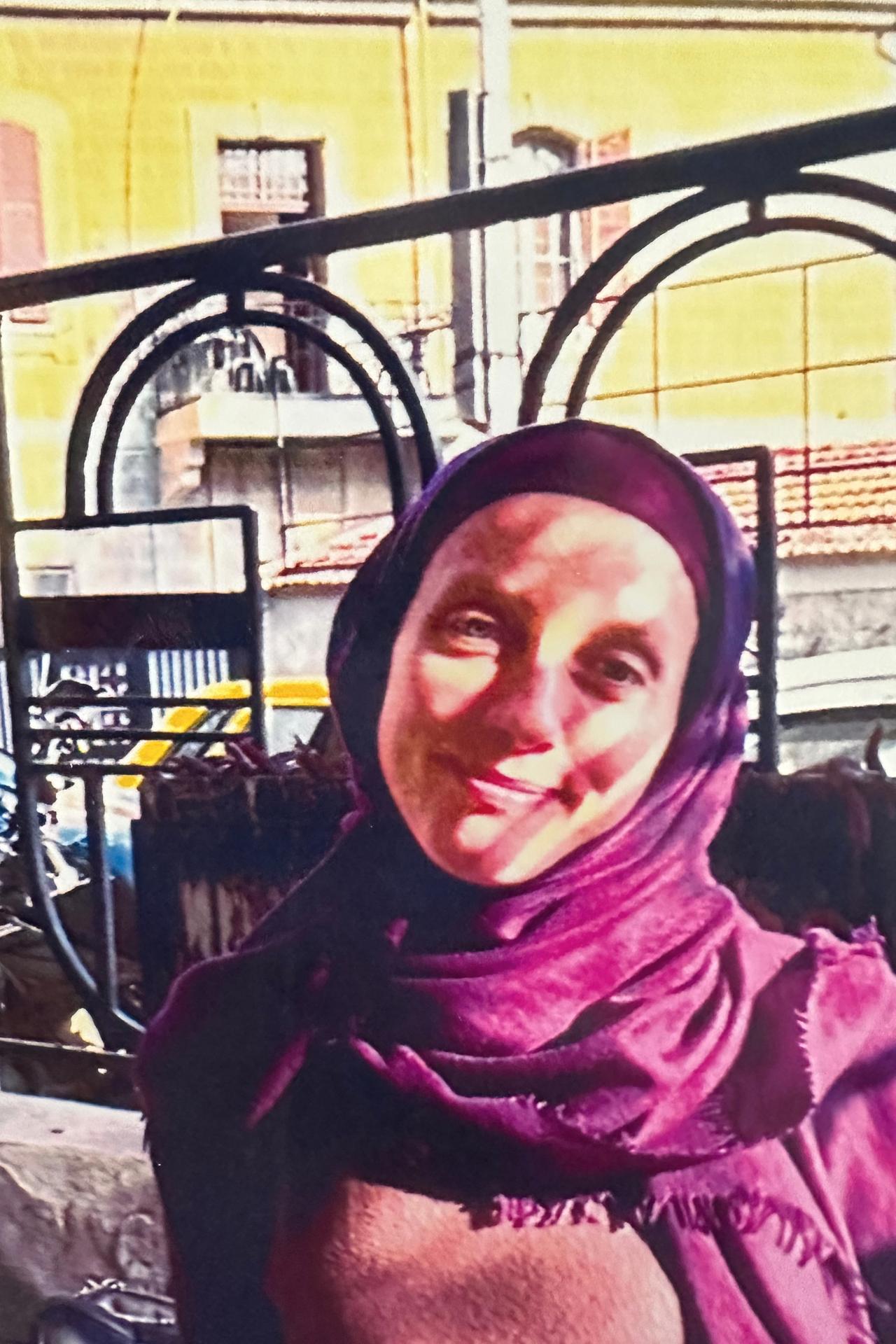 Shelly Kittleson trägt ein Kopftuch und lächelt in die Kamera. Shelly Kittleson trägt ein Kopftuch und lächelt in die Kamera.