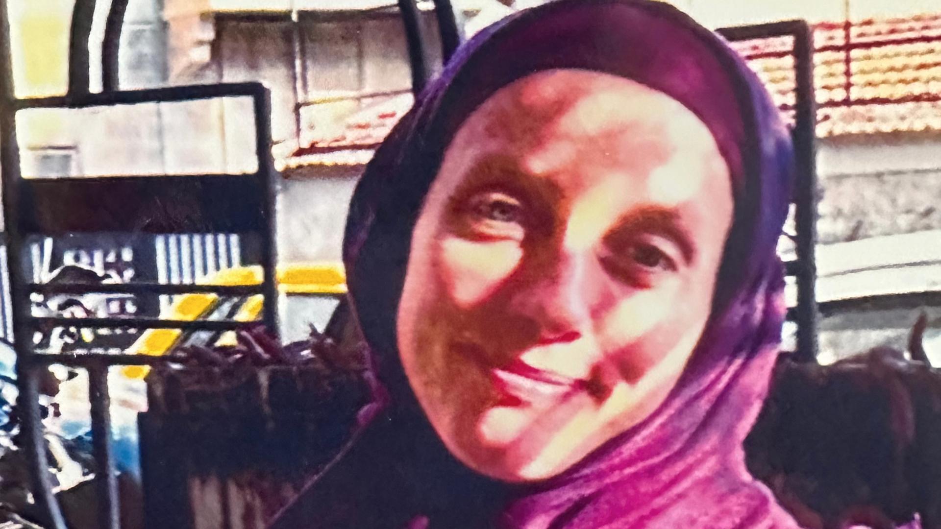 Shelly Kittleson trägt ein Kopftuch und lächelt in die Kamera. Shelly Kittleson trägt ein Kopftuch und lächelt in die Kamera.