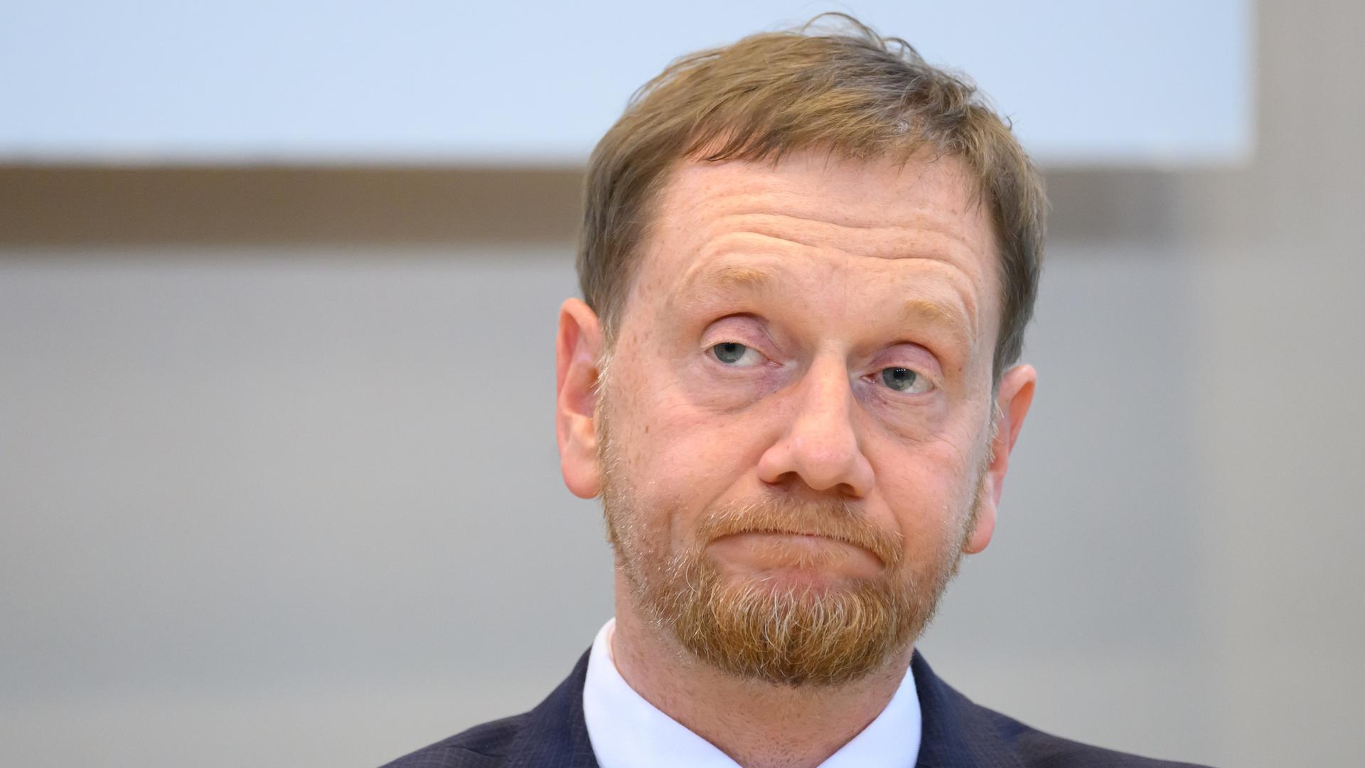 Michael Kretschmer von der CDU. Er ist der Minister-Präsident von Sachsen. Er verzieht das Gesicht. 