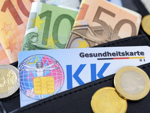 Eine Gesundheitskarte in einer Geldbörse. Drumherum liegen Euroscheine. Eine Gesundheitskarte in einer Geldbörse. Drumherum liegen Euroscheine.