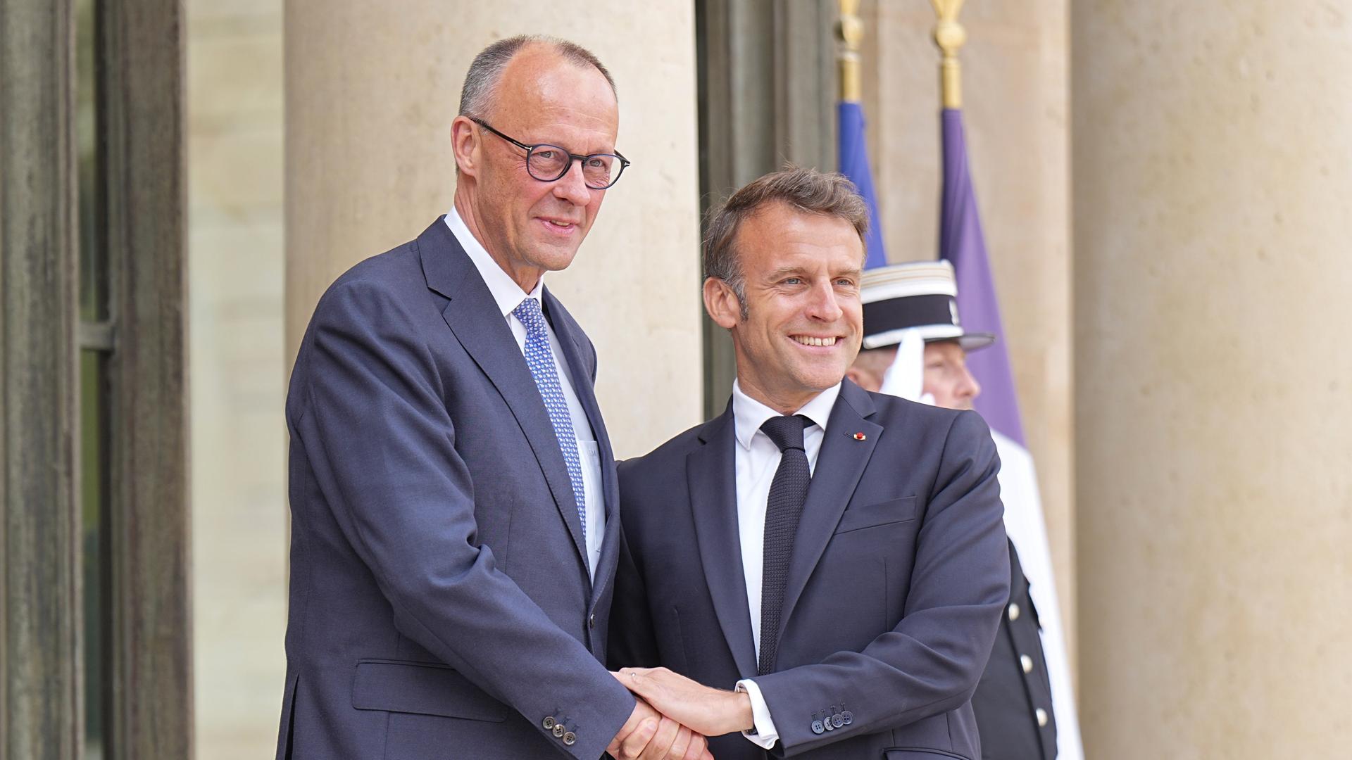 Der französische Präsident Emmanuel Macron (r) begrüßt Bundeskanzler Friedrich Merz (CDU) bei seinem Antrittsbesuch in Paris. 