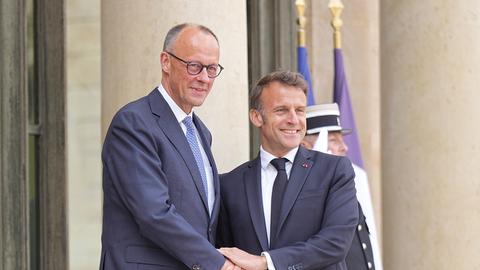 Der französische Präsident Emmanuel Macron (r) begrüßt Bundeskanzler Friedrich Merz (CDU) bei seinem Antrittsbesuch in Paris. 