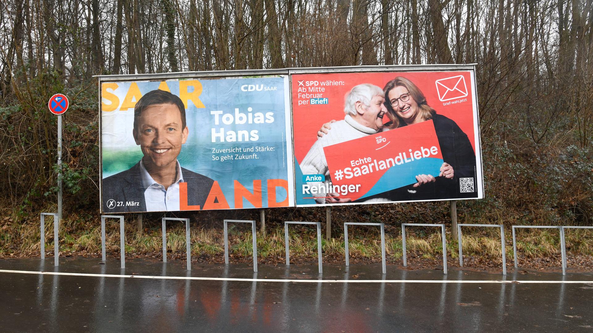 Wahlplakate von CDU und SPD hängen an einer Straße in Saarbrücken nebeneinander.