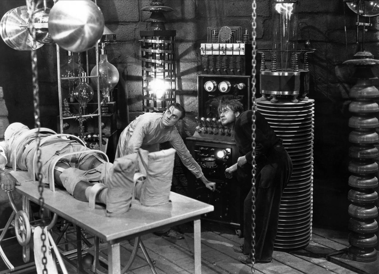 Filmszene aus der Frankenstein-Verfilmung von 1931: Colin Clive und Dwight Frye als Dr. Henry Frankenstein und Fritz bei der Erschaffung des künstlichen Wesens durch Elektrizität im Labor.