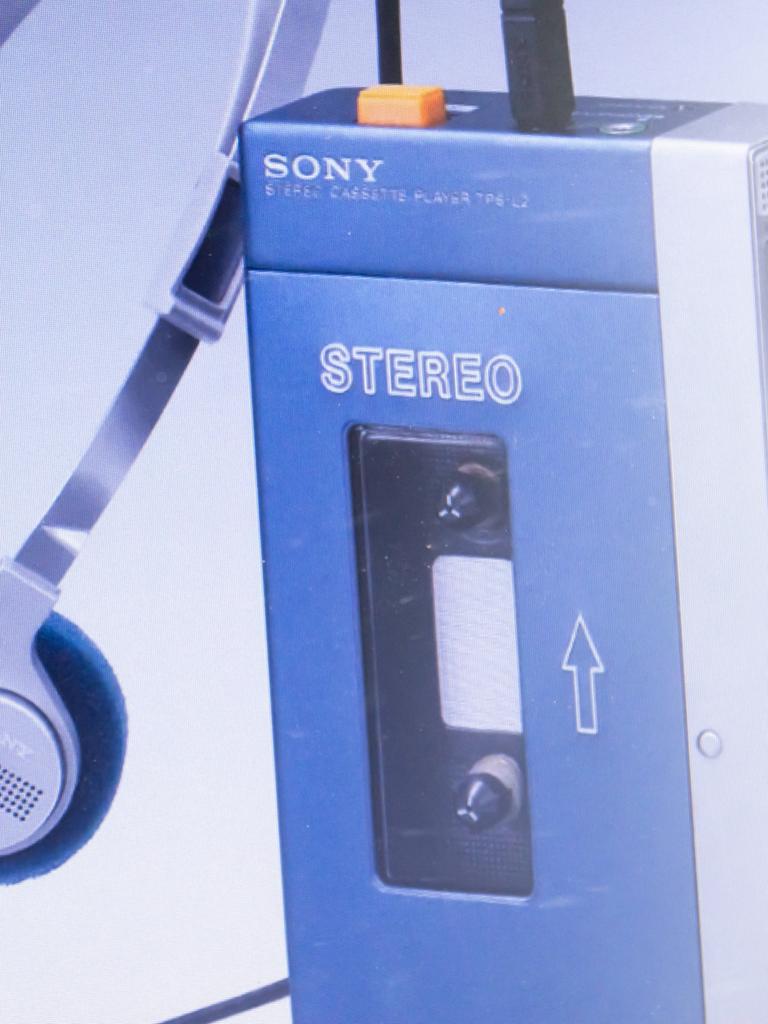Auf dem Bild ist ein mobiles Kassettenabspielgerät der Firma Sony, ein sogenannter Walkman, zu sehen, daneben der dazugehörige Kopfhörer.  Auf dem Bild ist ein mobiles Kassettenabspielgerät der Firma Sony, ein sogenannter Walkman, zu sehen, daneben der dazugehörige Kopfhörer.