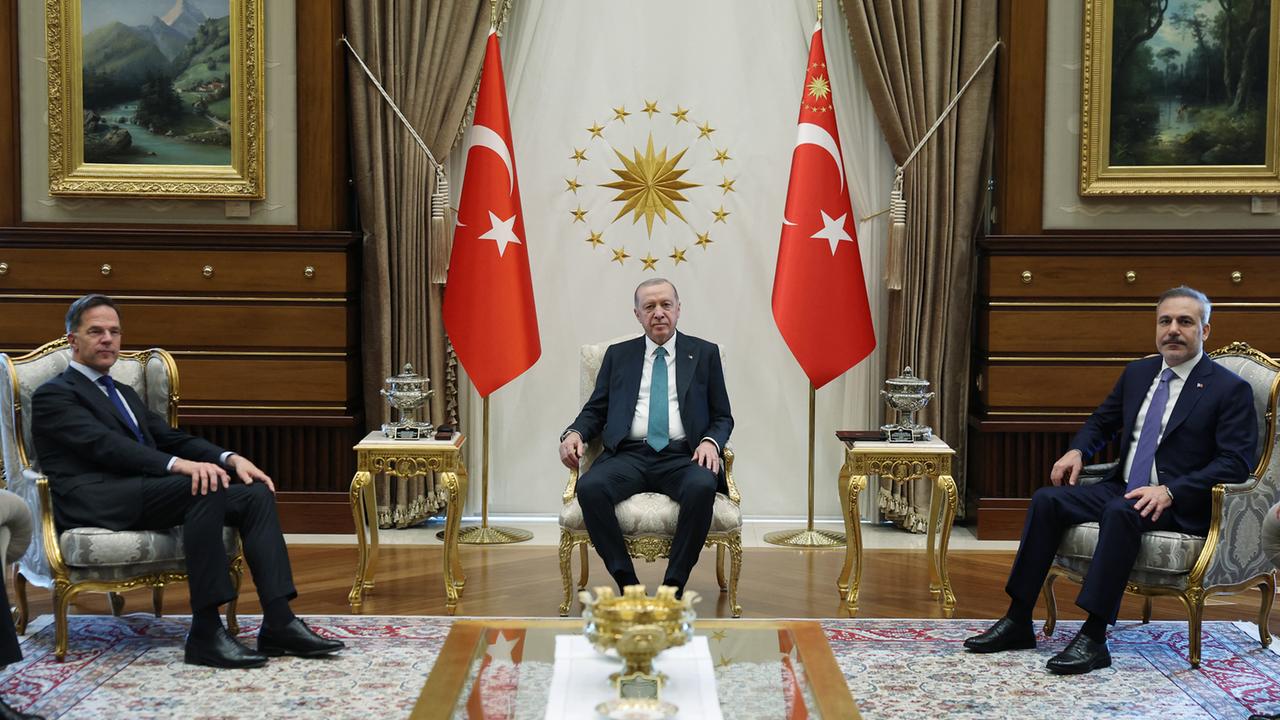 Der türkische Präsidenten Recep Tayyip Erdogan (Mitte), NATO-Generalsekretär Mark Rutte (links) und der türkische Außenminister Hakan Fidan (rechts) bei einem Treffen im Präsidentenpalast in Ankara. Sie sitzen auf goldenen Stühlen.