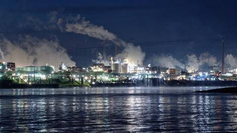Die Lichter des Chemparks in Leverkusen spiegeln sich im Wasser des Rheins. 