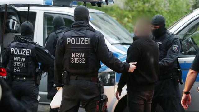 Polizisten nehmen bei einer Razzia im Kampf gegen die organisierte Kriminalität eine verdächtige Person mit. (Archivbild)