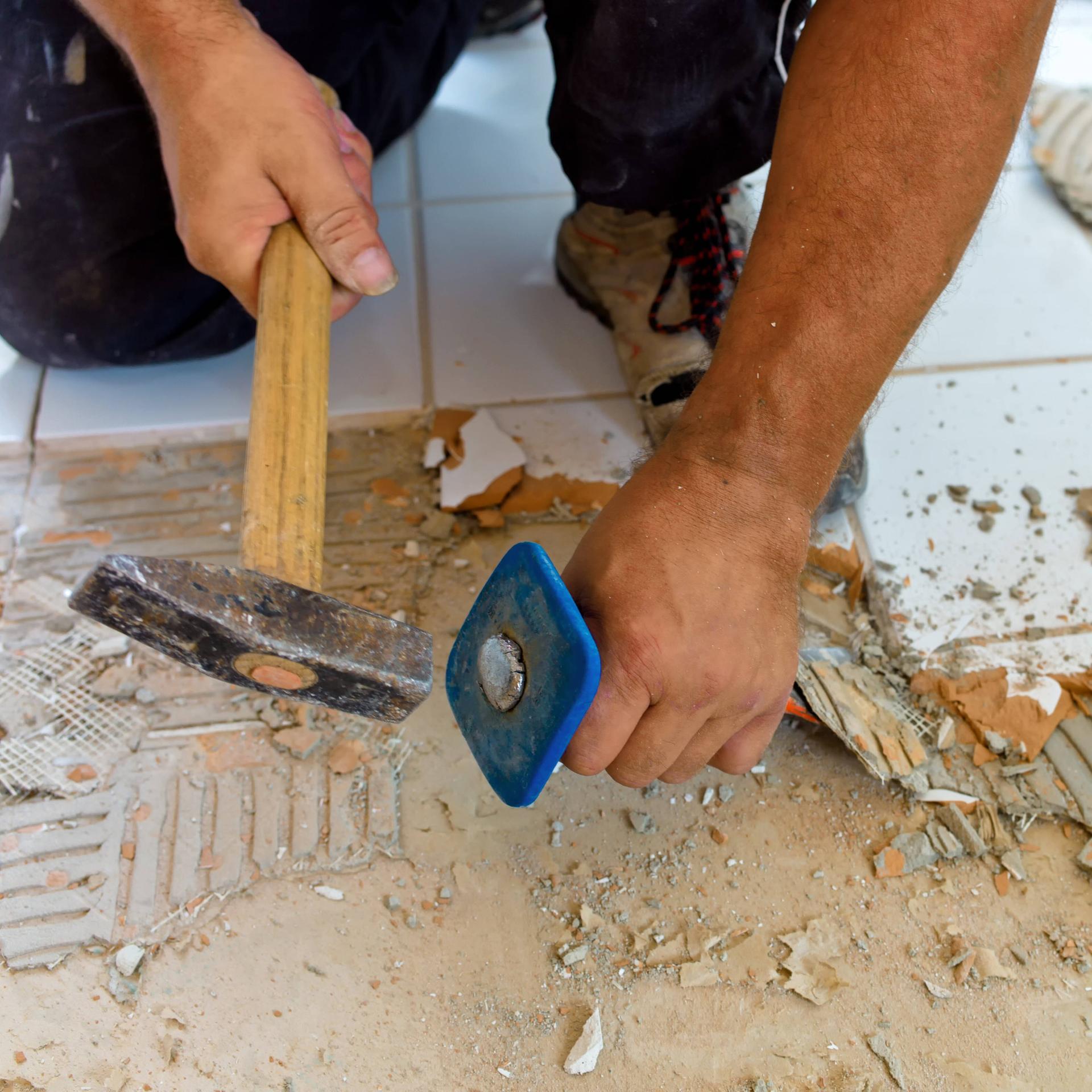 Ein Fliesenleger entfernt alte Fliesen im Bad, das Bad wird neu gefliest. Bauschutt, Handwerker, Fliesenleger, Hammer, Meissel, Meißel, McPKST McP_KST_2023_026698 *** a Tilers removed Old Tiles at Bath, the Bathroom will New tiled rubble, Handyman, Tiler, Hammer, Chisel, Chisel, McPKST McP Corporation tax 2023 026698 McPKST