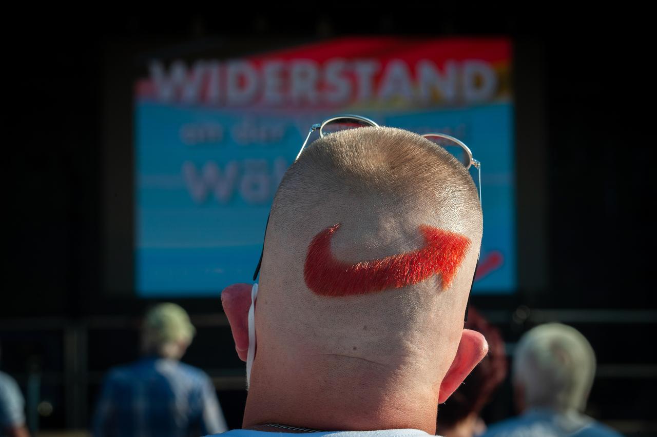 Ein AfD-Anhänger bei einer Veranstaltung der Partei. Auf den Hinterkopf hat er sich das AfD-Parteilogo rasiert und rot gefärbt.