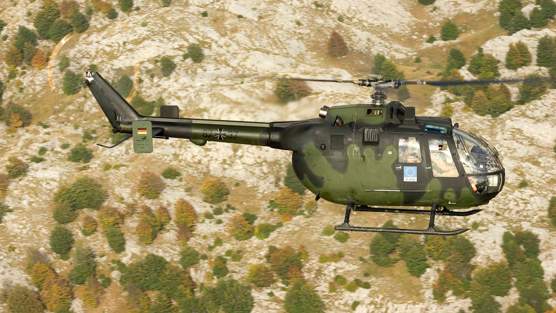 Ein deutscher Armee-Helicopter Bo-105P im Einsatz über einer kargen Landschaft in Bosnien-Herzegowina.
