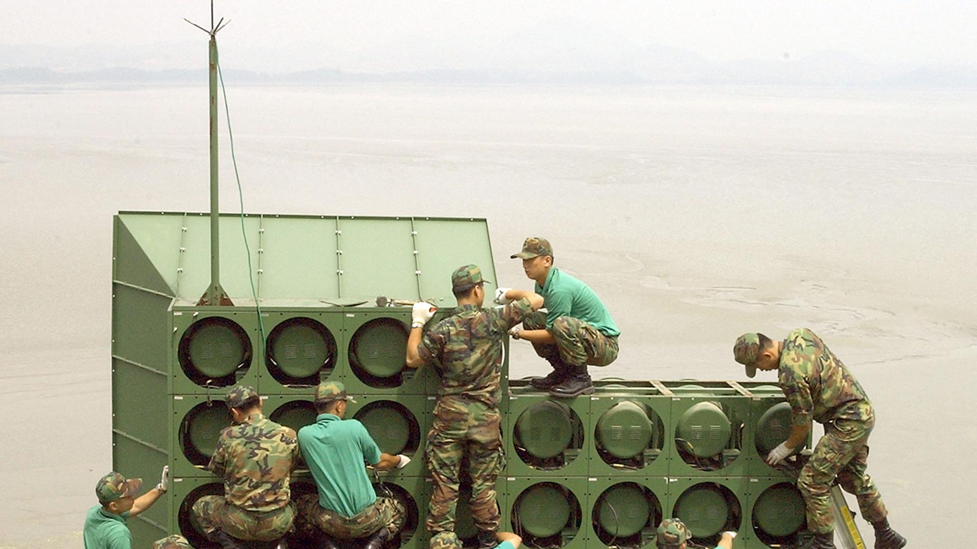 Soldaten bauen eine große Lautsprecher-Anlage ab.