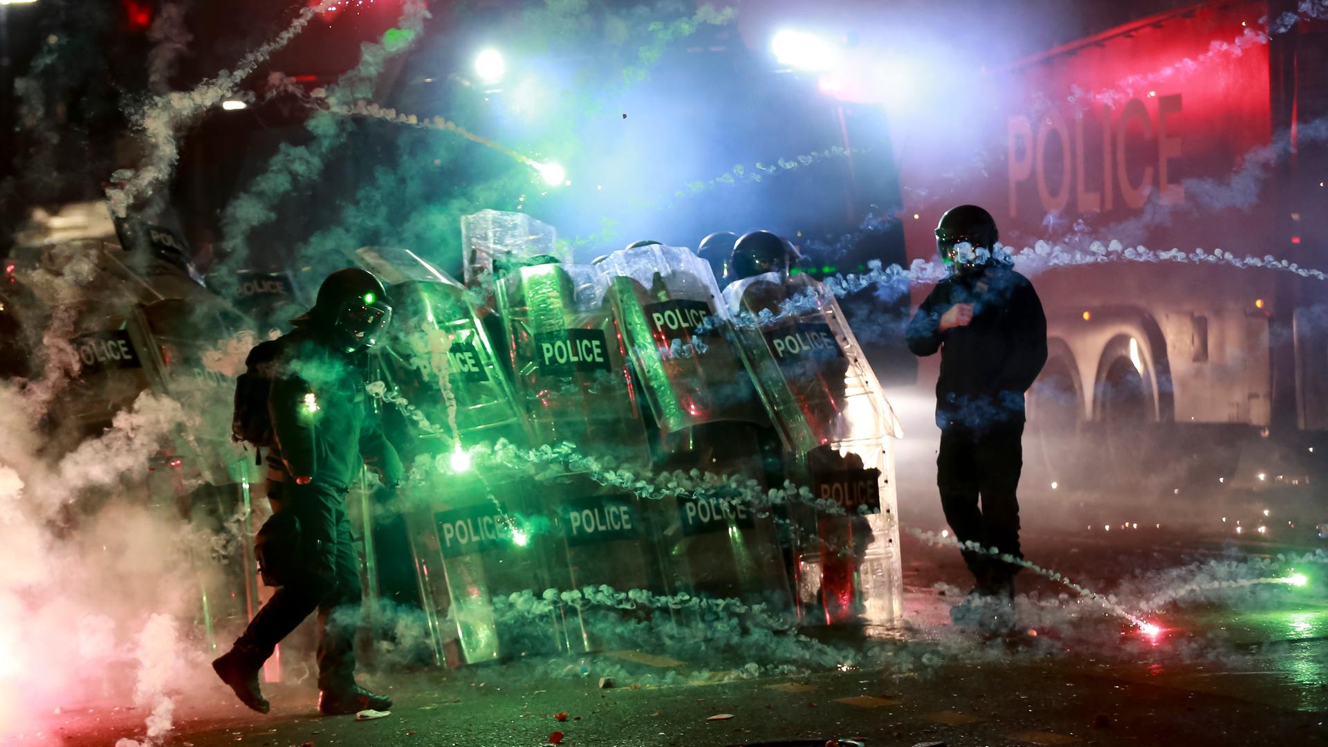 Demonstranten in Georgiens Hauptstadt Tiflis werfen Pyrotechnik und Feuerwerk auf Polizisten, die eine Straße blockieren.