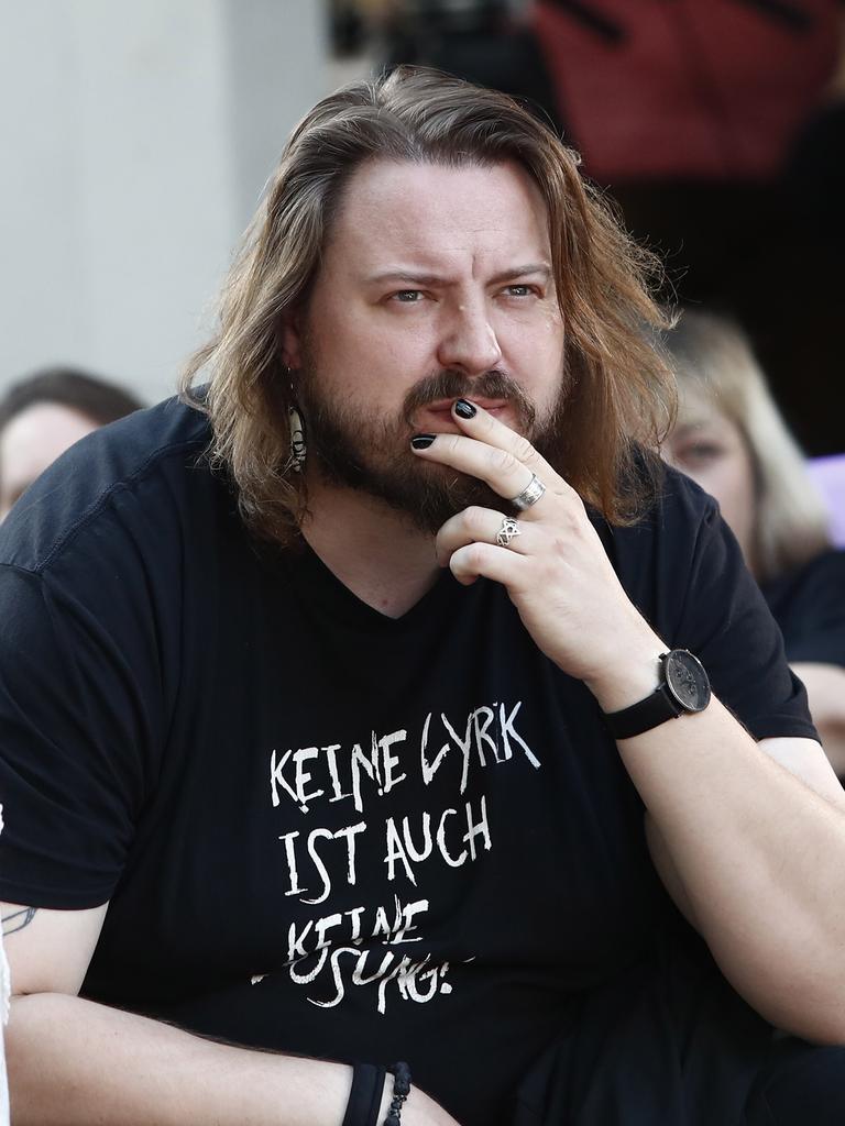 Martin Piekar legt die Hand an den Mund und blickt ernst ins Off. Er hat etwas längere Haare und einen Vollbart
