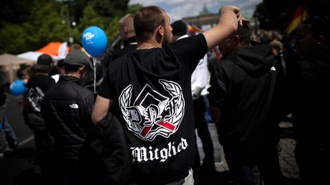 Blick auf eine Demonstration der als rechtsextrem eingestuften Partei AfD, der Querdenker-Bewegung und anderen rechten Gruppierungen. Im Vordergrund sieht man einen Demonstrant von hinten mit einem schwarzen T-Shirt mit einem Runenzeichen. Blick auf eine Demonstration der als rechtsextrem eingestuften Partei AfD, der Querdenker-Bewegung und anderen rechten Gruppierungen. Im Vordergrund sieht man einen Demonstrant von hinten mit einem schwarzen T-Shirt mit einem Runenzeichen.