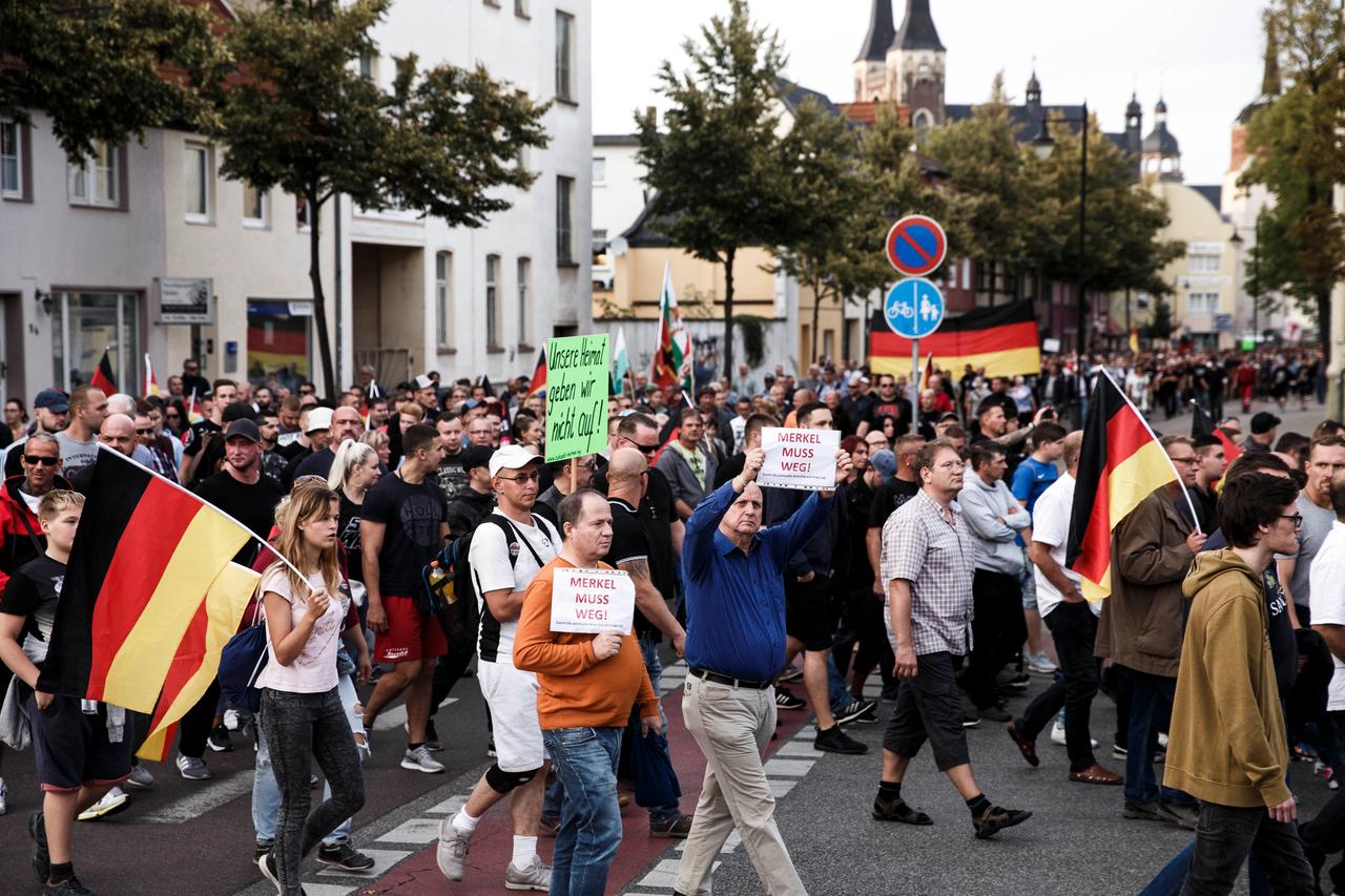 Personen mit Deutschlandflaggen und Pappschildern marschieren durch Koethen. Auf den Transparenten und Schildern steht "Merkel muss weg" oder "Unsere Heimat geben wir nicht auf".
