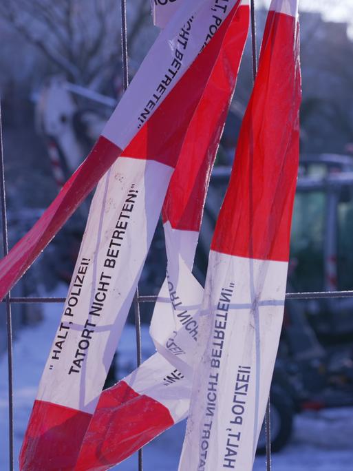 Ein Absperrband "Halt Polizei! Tatort nicht betreten!" hängt an einem Zaun um das Heizkraftwerk Lichterfelde.