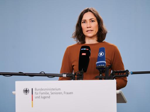 Bundesfamilienministerin Anne Spiegel steht an einem Rednerpult mit Mikrofonen von RTL/ntv und ARD.