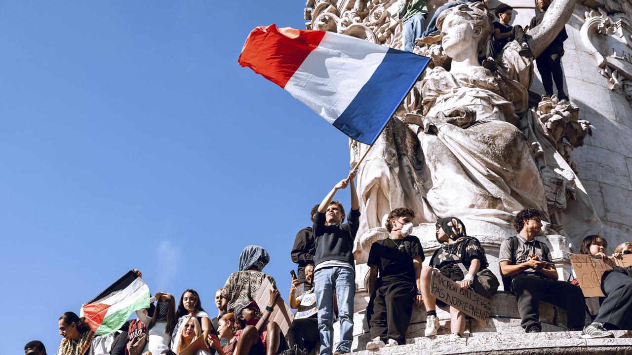 Demonstranten auf der Statue der Republik in Paris schwenken eine große Frankreich-Flagge. Demonstranten auf der Statue der Republik in Paris schwenken eine große Frankreich-Flagge.