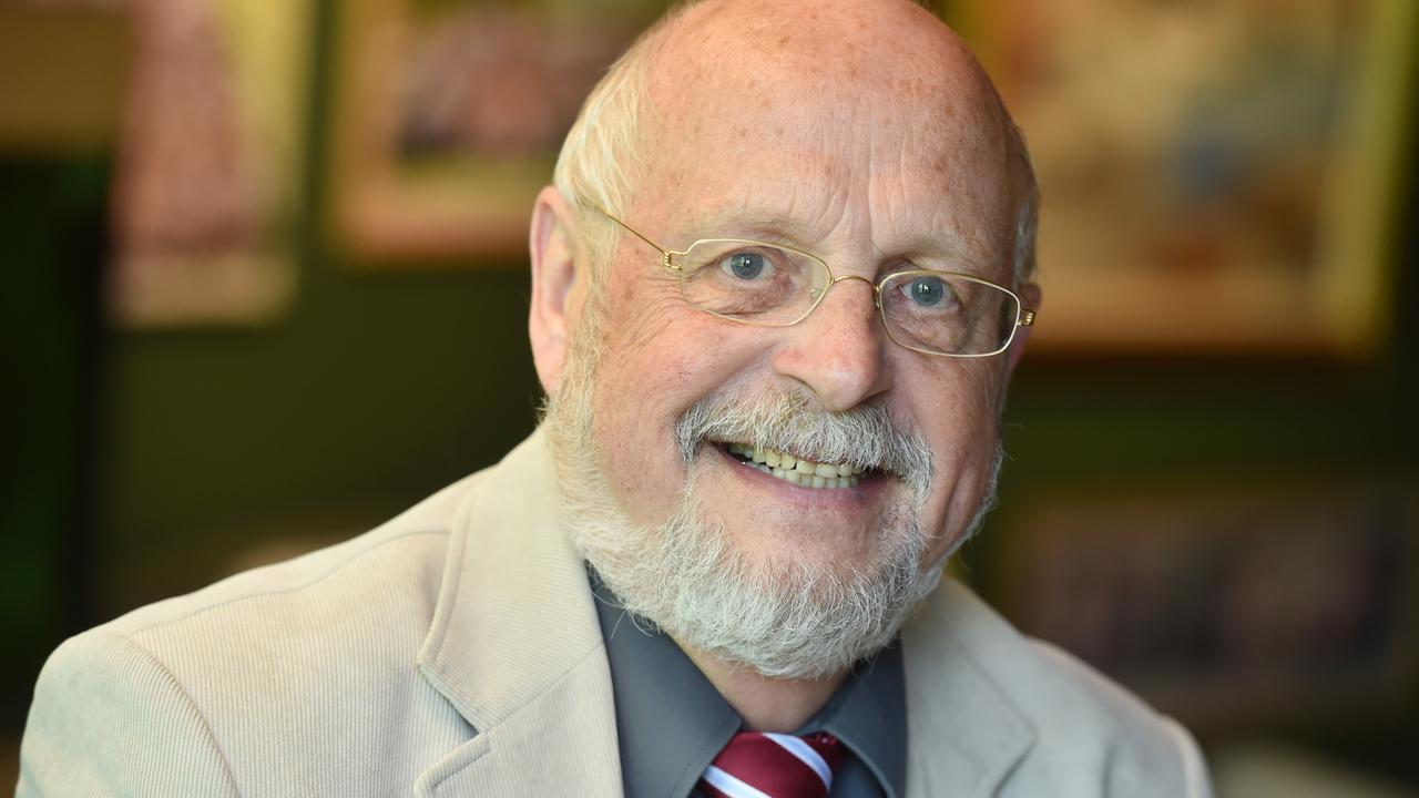 Tom Hoyem lächelt in die Kamera. Er trägt eine Brille mit schmalem goldenen Rand und hat einen gestutzten weißen Vollbart.