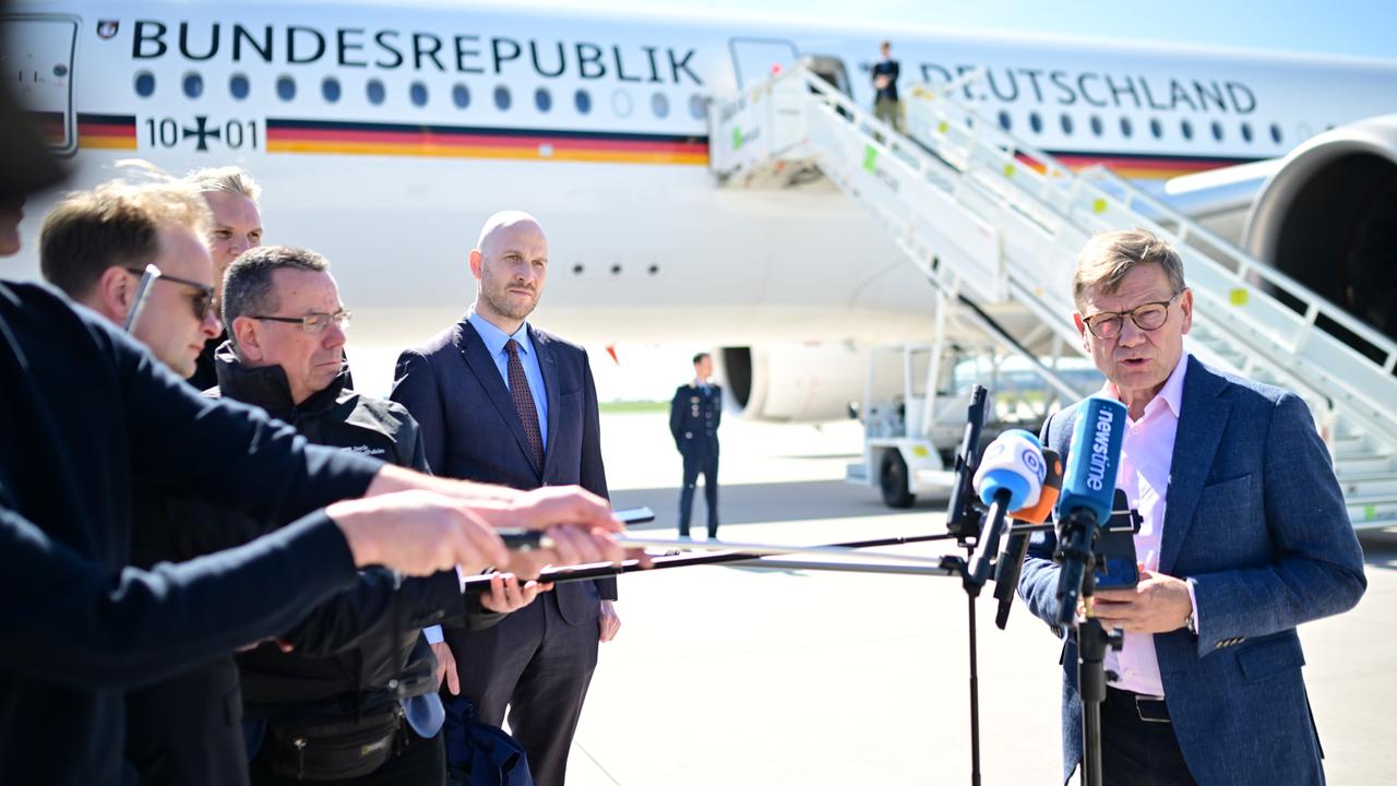 Johann Wadephul (CDU, r), Außenminister, spricht auf dem militärischen Teil des Flughafens Berlin Brandenburg an einem Flugzeug der Flugbereitschaft zu den Medien.
