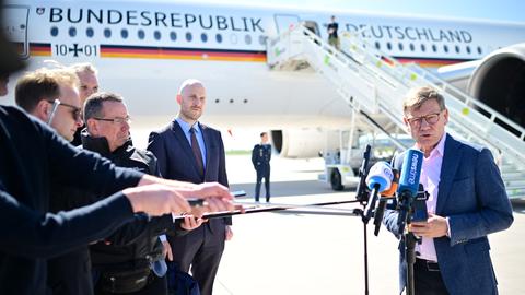Johann Wadephul (CDU, r), Außenminister, spricht auf dem militärischen Teil des Flughafens Berlin Brandenburg an einem Flugzeug der Flugbereitschaft zu den Medien.