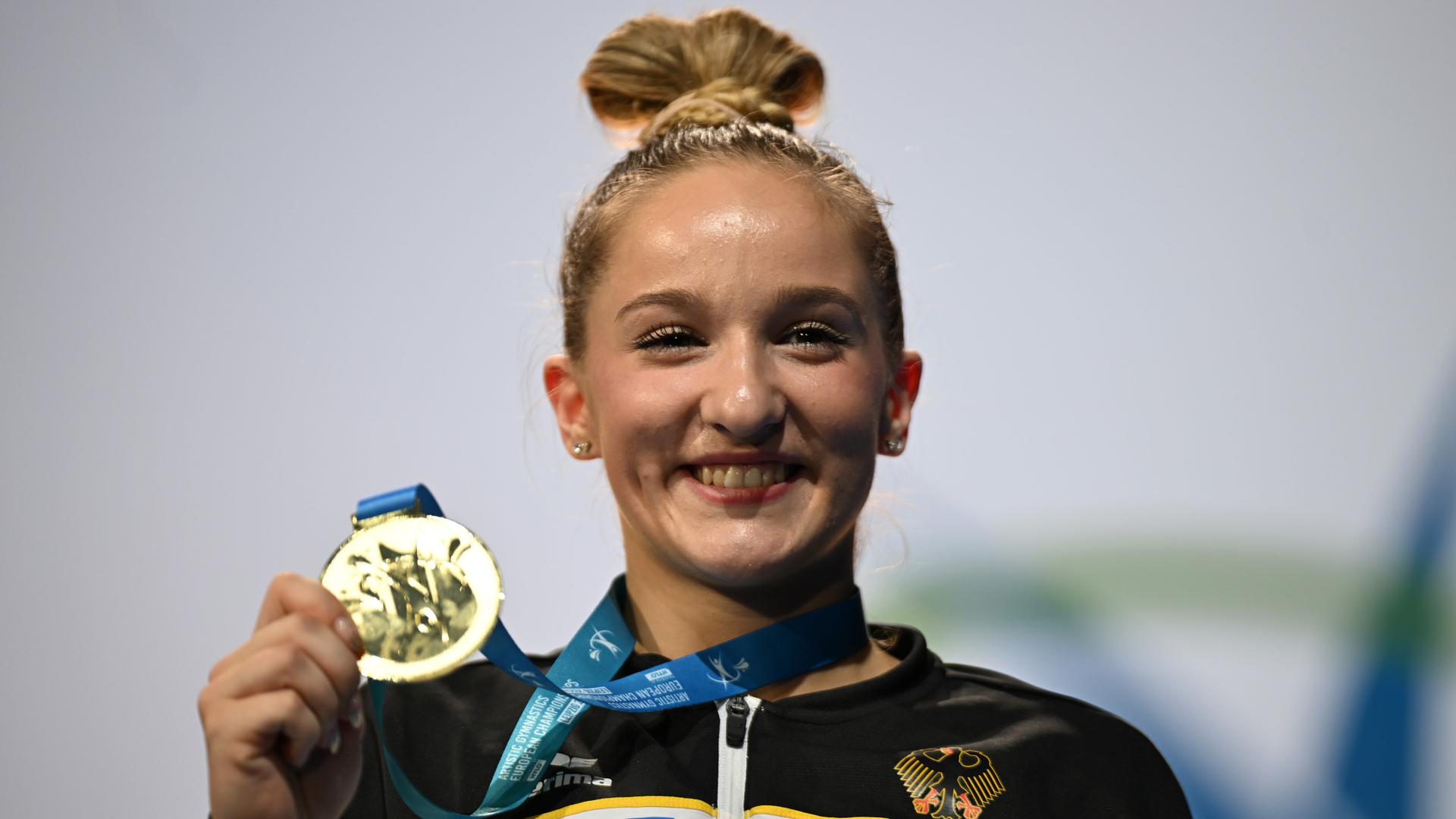 Die Gewinnerin Karina Schönmaier aus Deutschland feiert ihre Goldmedaille auf dem Podium bei der Turn-EM in Leipzig.