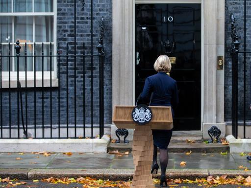 Die britische Premierministerin Liz Truss kehrt nach ihrem Statement vor der 10 Downing Street den Zuschauern den Rücken.