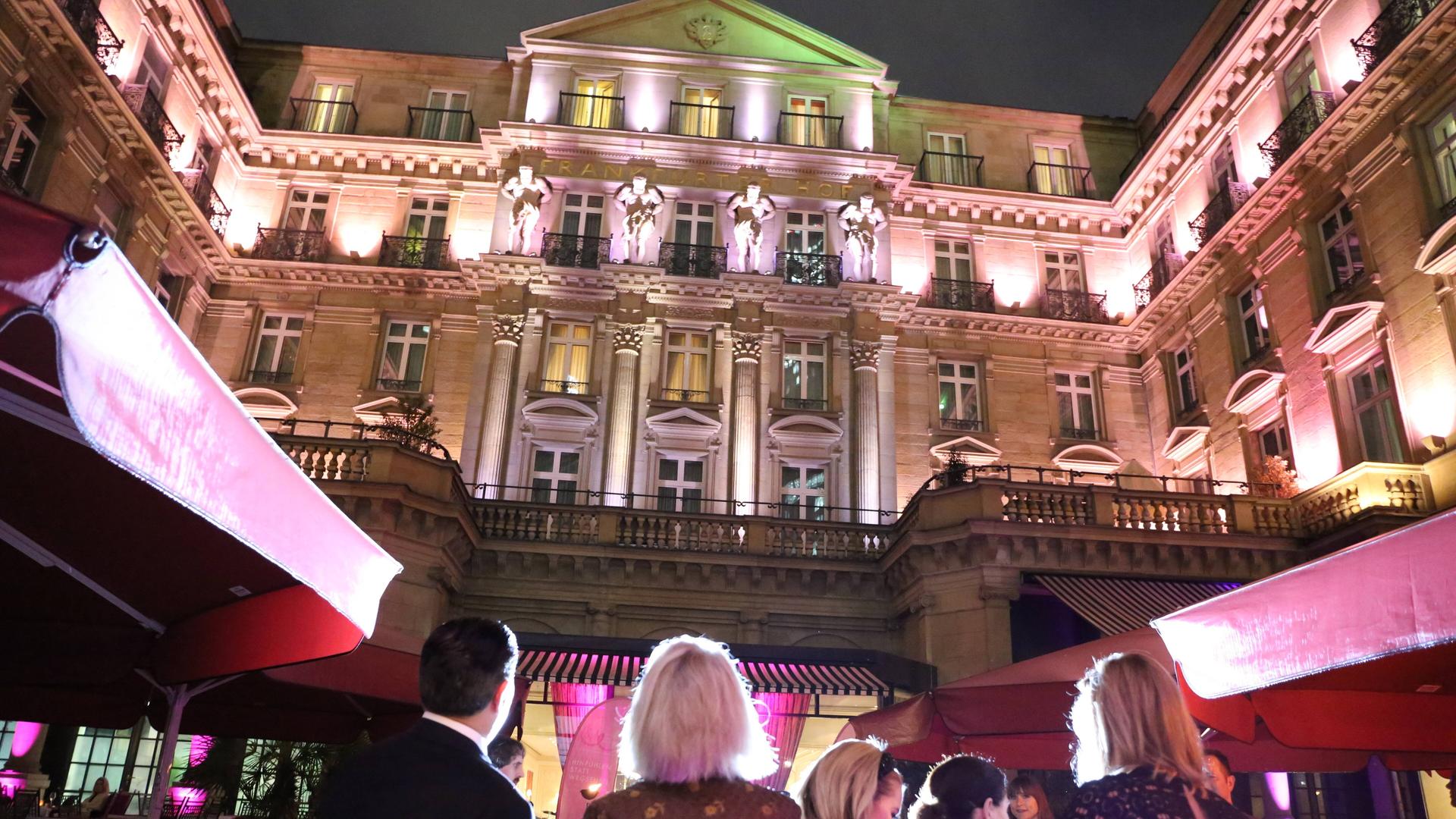 Das Grandhotel Steigenberger Frankfurter Hof abends erleuchtet zur Eröffnung einer Veranstaltung mit Gästen. Das Grandhotel Steigenberger Frankfurter Hof abends erleuchtet zur Eröffnung einer Veranstaltung mit Gästen.