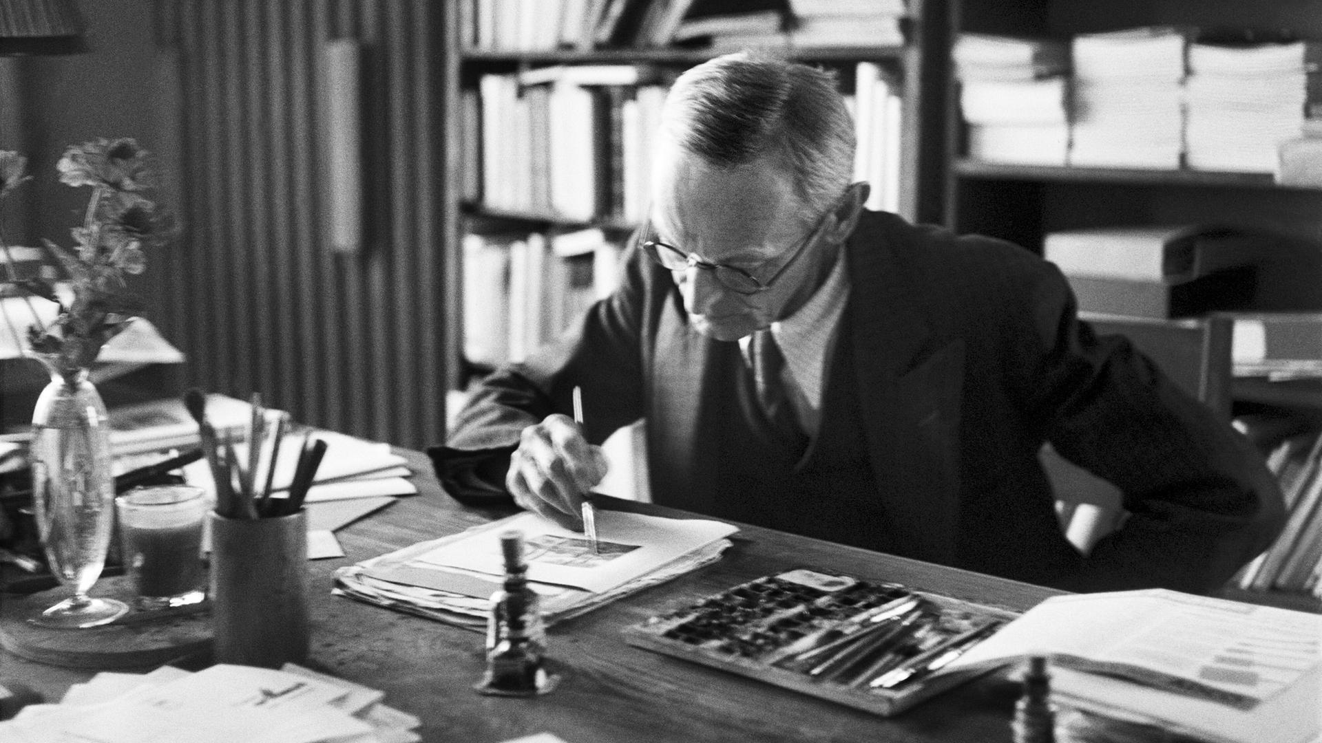 Der Schriftsteller Hermann Hesse arbeitet an einer Illustration im Arbeitszimmer seinen Hauses in Montagnola, Tessin, undatierte Aufnahme. 