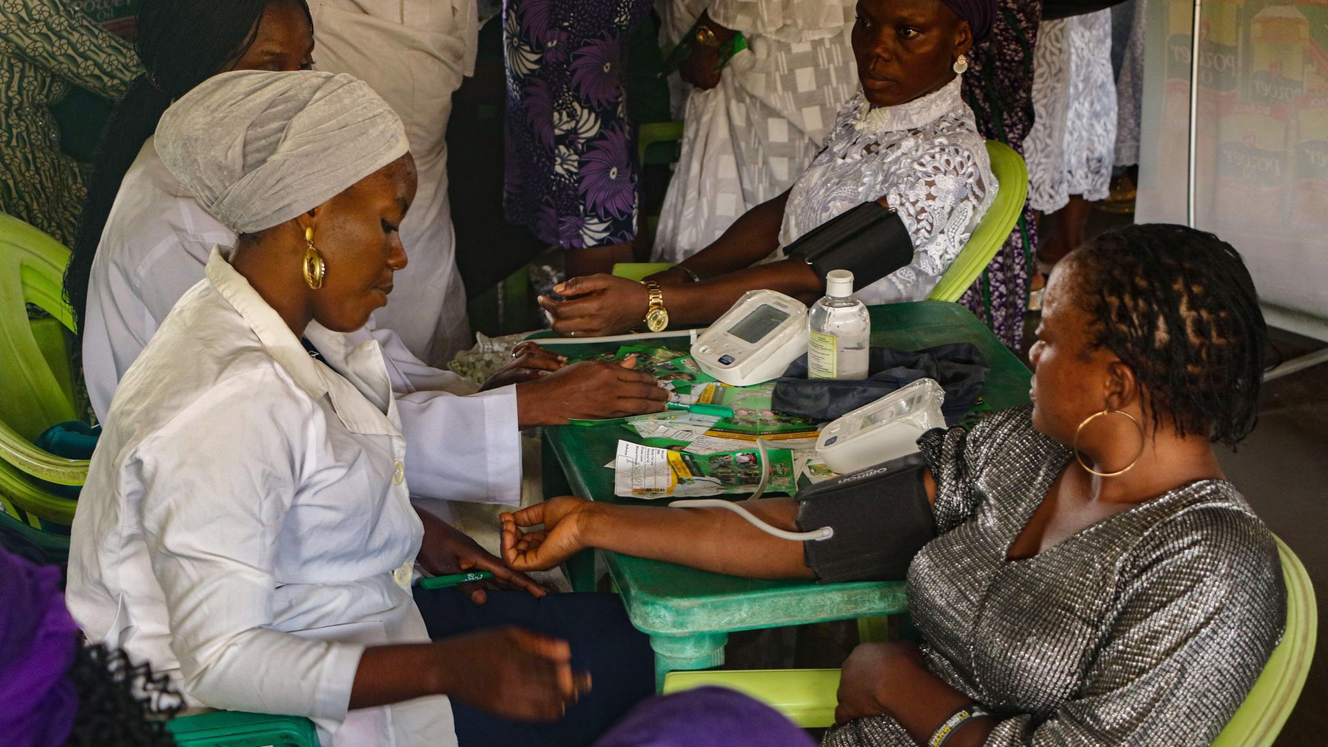 Eine Krankenschwester behandelt eine Frau während einer kostenlosen medizinischen Untersuchung anlässlich des Internationalen Tages der Frau in Lagos, Nigeria.