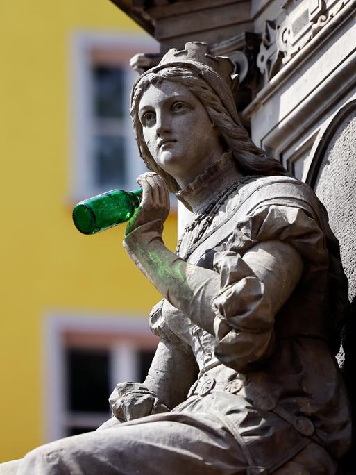 Die Statue der Griet am Jan von Werth-Brunnen auf dem Altermarkt hat jemand als Scherz eine leere Bierflasche in die Hand gedrückt.