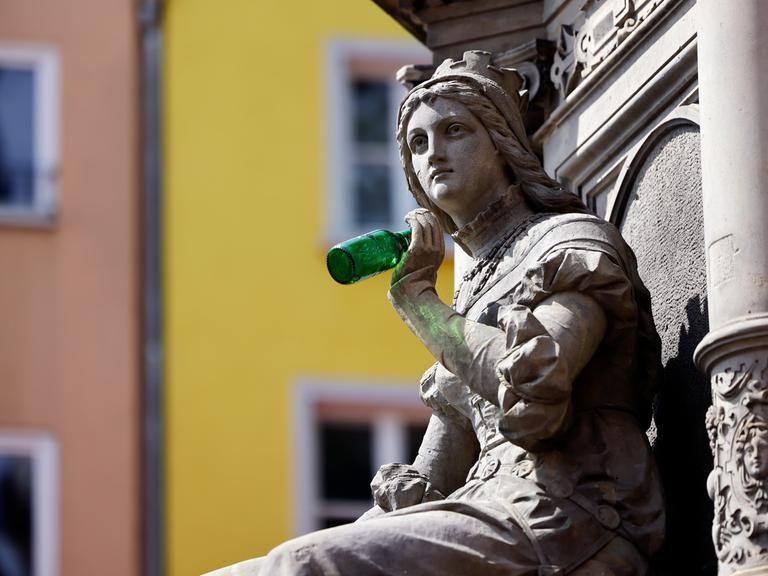 Die Statue der Griet am Jan von Werth-Brunnen auf dem Altermarkt hat jemand als Scherz eine leere Bierflasche in die Hand gedrückt.