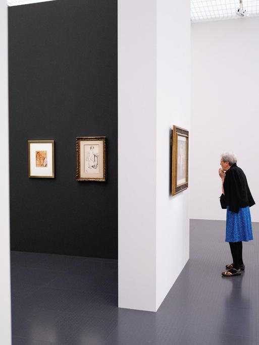 Eine Frau betrachtet im Centre Pompidou in Metz ein Bild. Um sie herum sind auch andere Bilder.