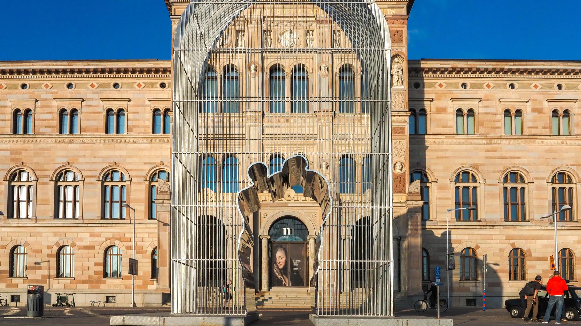 Die Stahlskulptur „Arch“ des chinesischen Künstlers Ai Weiwei wurde vor dem Nationalmuseum in Stockholm aufgestellt. Die 12 Meter hohe, käfigartige Struktur aus Stahl hat in ihrer Mitte eine Aussparung, die die Konturen zweier Menschen darstellt. Die Stahlskulptur „Arch“ des chinesischen Künstlers Ai Weiwei wurde vor dem Nationalmuseum in Stockholm aufgestellt. Die 12 Meter hohe, käfigartige Struktur aus Stahl hat in ihrer Mitte eine Aussparung, die die Konturen zweier Menschen darstellt.