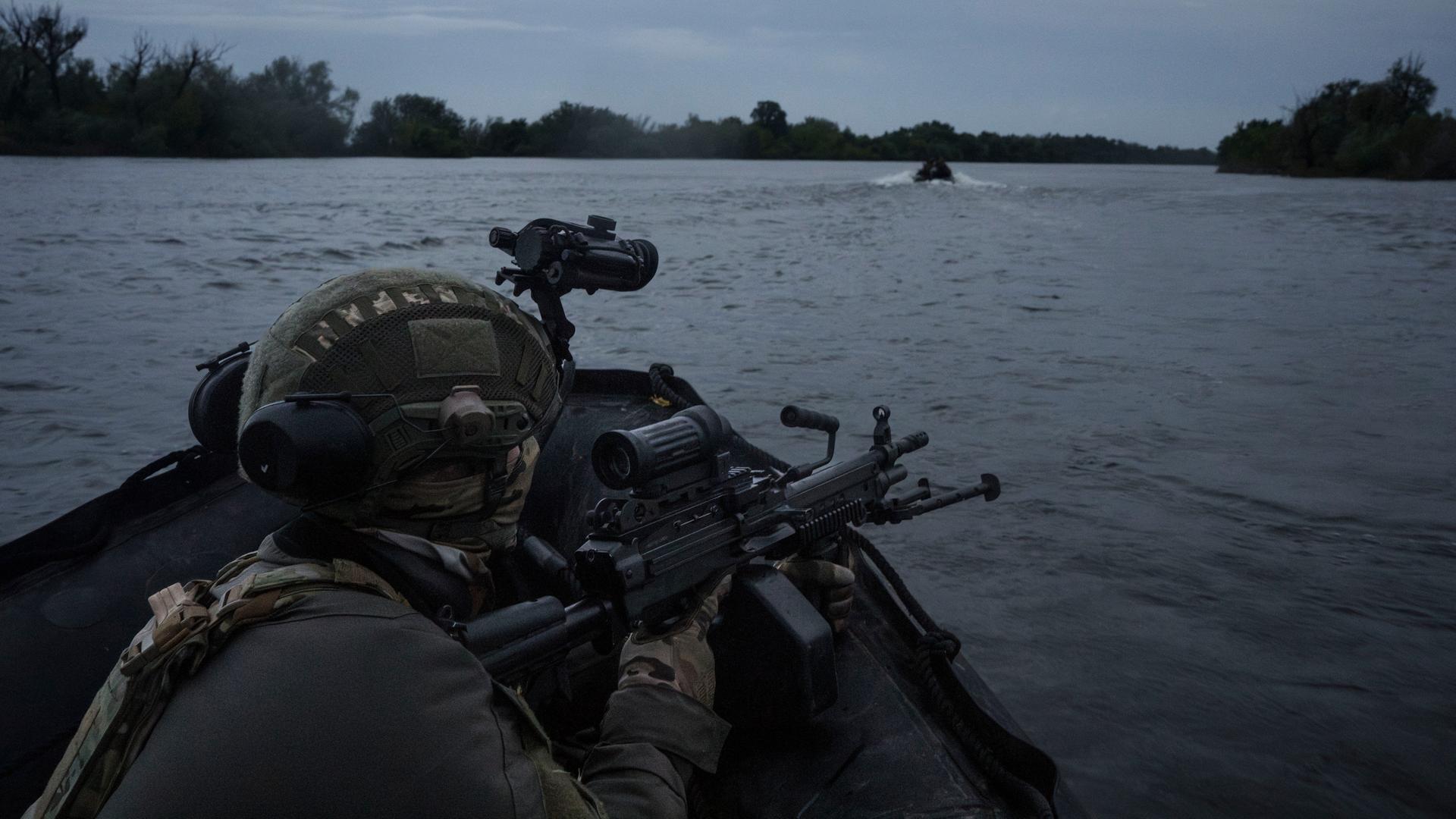 Ukrainische Soldaten fahren mit einem Boot auf dem Fluss Dnipro an der Frontlinie in der Nähe von Cherson.