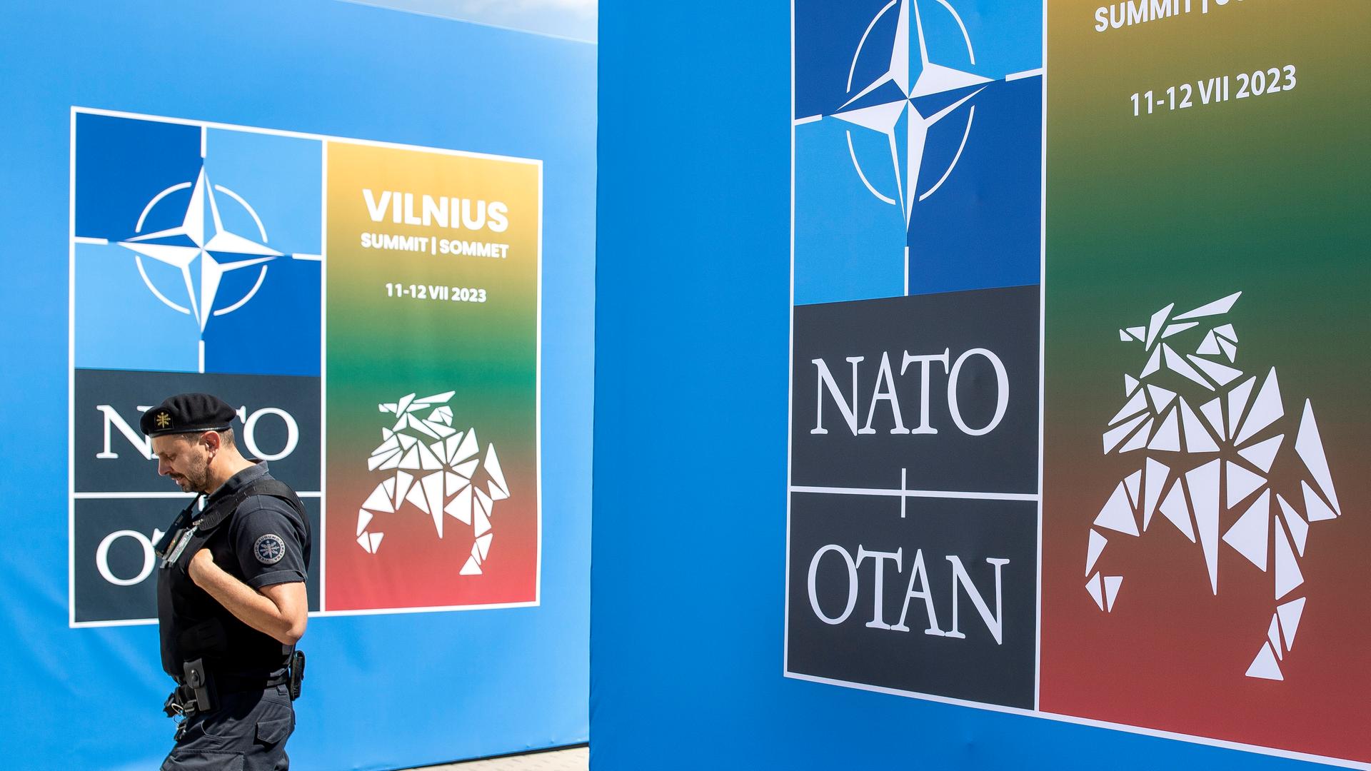 Sicherheitskraft vor dem Logo des NATO-Gipfels im litauischen Vilnius.
