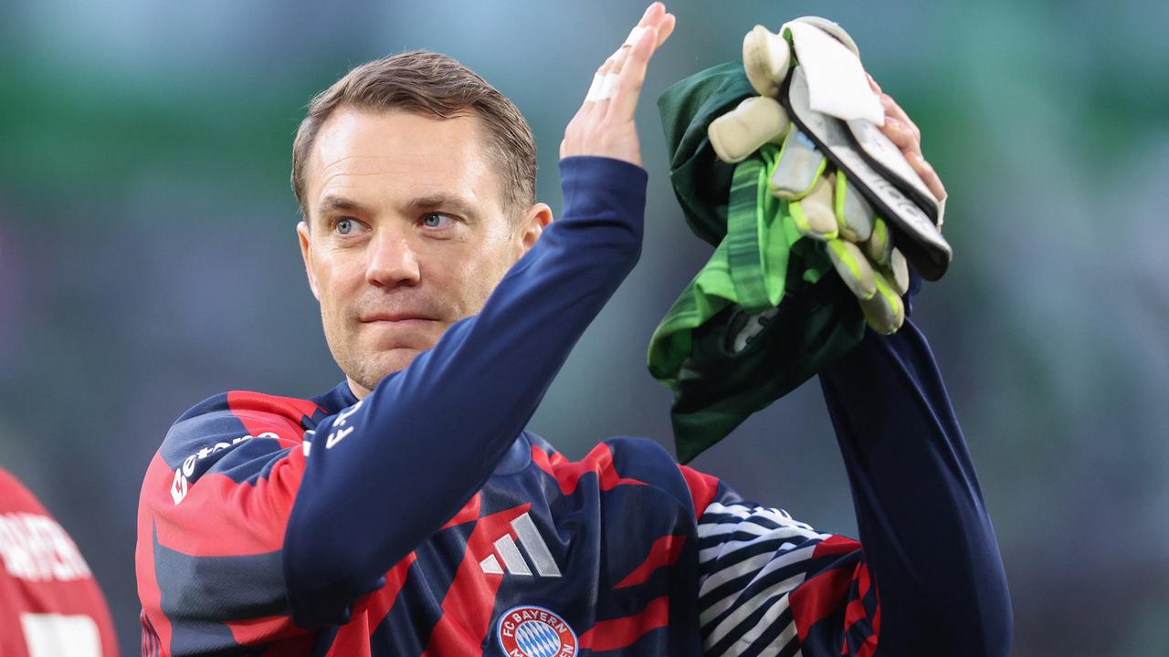 Bayern Münchens Torhüter Manuel Neuer klatscht zufrieden lächelnd in die Hände. 