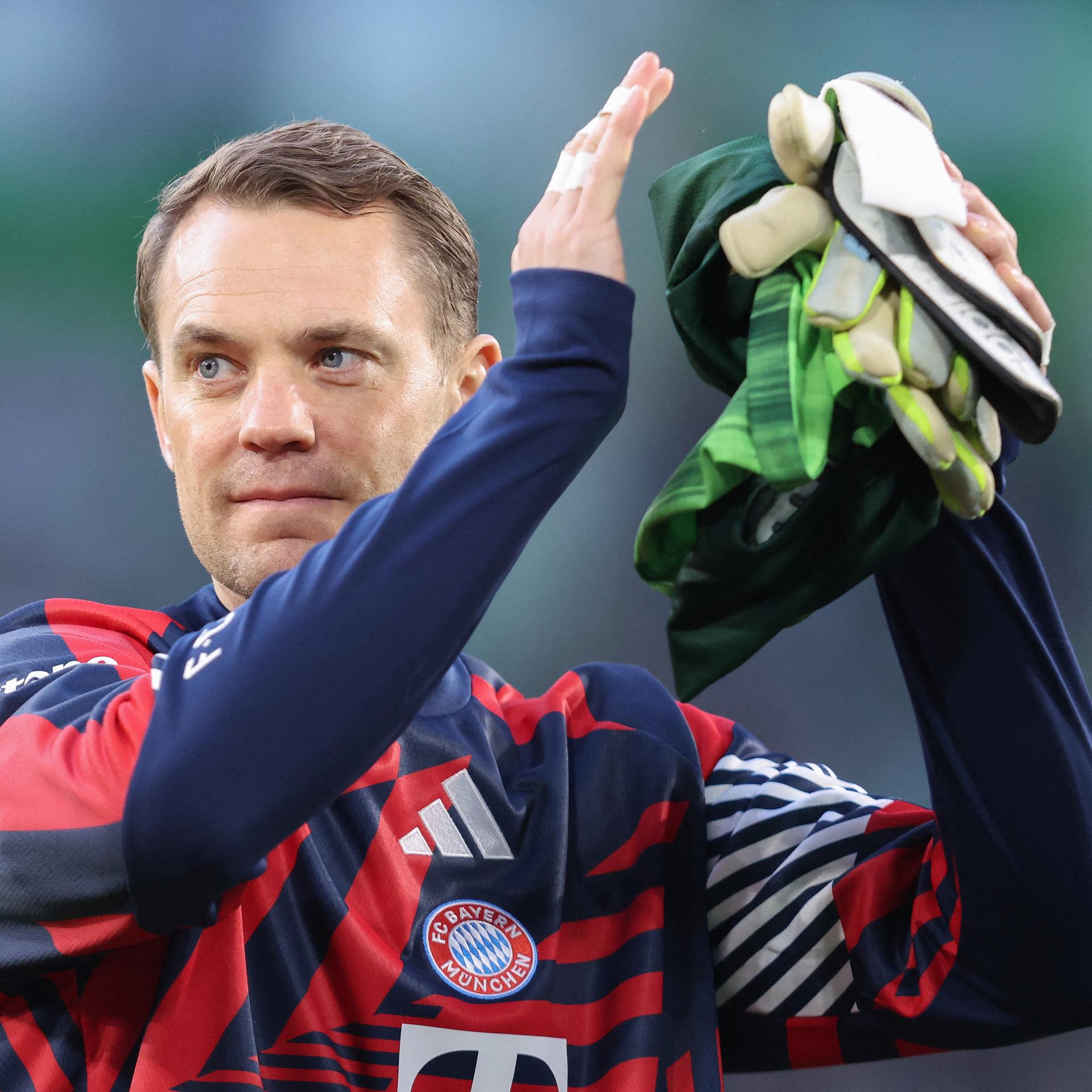 Bayern Münchens Torhüter Manuel Neuer klatscht zufrieden lächelnd in die Hände. 
