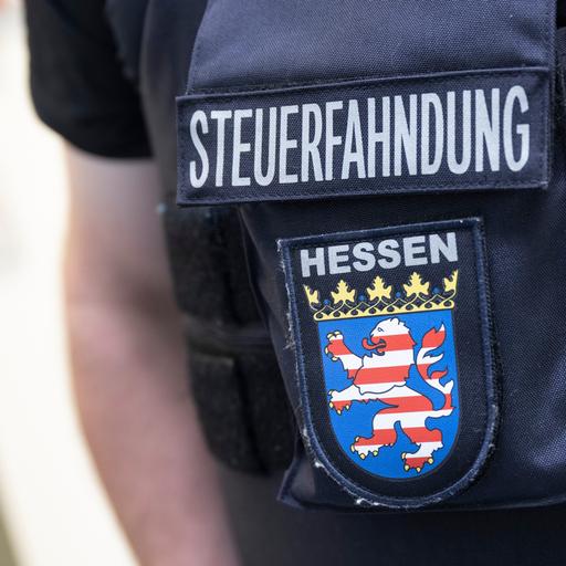 Im Rahmen einer Großrazzia gegen Schwarzarbeit durchsuchen Beamte des Zoll Firmenräume in Frankfurt. Dabei steht ein Beamter der Steuerfahndung bereit.
