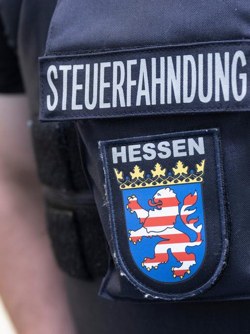 Im Rahmen einer Großrazzia gegen Schwarzarbeit durchsuchen Beamte des Zoll Firmenräume in Frankfurt. Dabei steht ein Beamter der Steuerfahndung bereit.